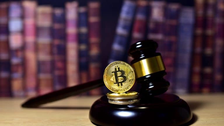 Martelo da Lei ao lado do Bitcoin e livros ao fundo