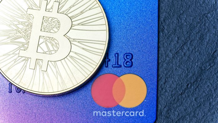 Moeda Bitcoin e cartão bandeira Mastercard