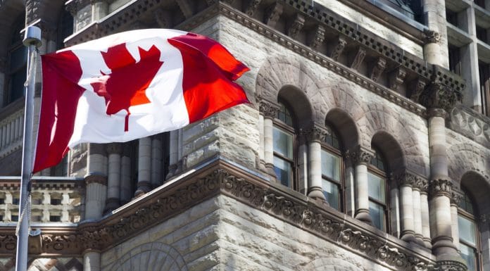 Bandeira do Canadá está acenando frente de um edifício