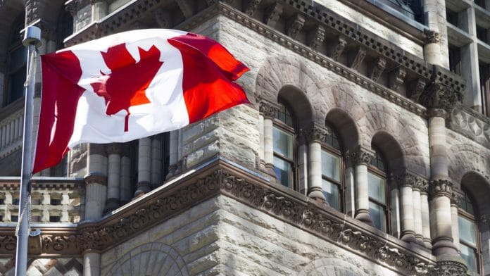 Bandeira do Canadá está acenando frente de um edifício