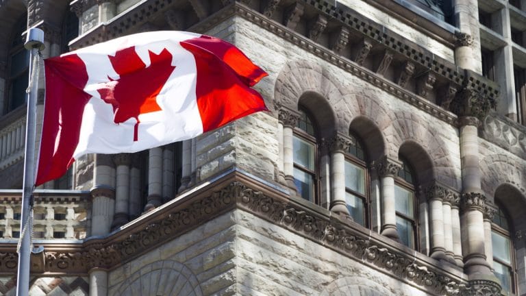 Bandeira do Canadá está acenando frente de um edifício