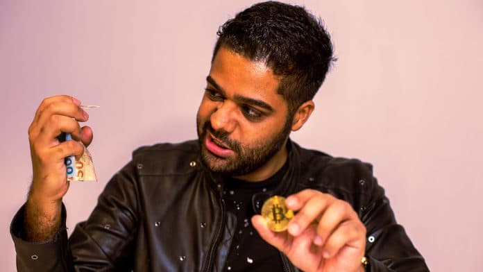 Homem olhando bravo para notas amassadas de Real brasileiro enquanto segura o Bitcoin
