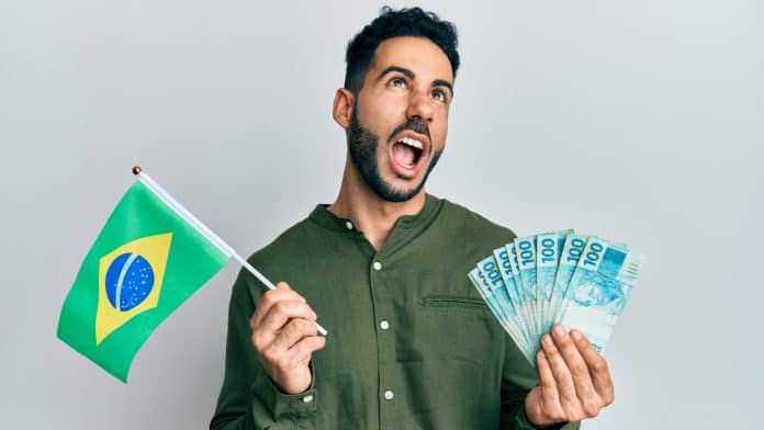 Jovem segurando a bandeira do Brasil e as notas reais com raiva