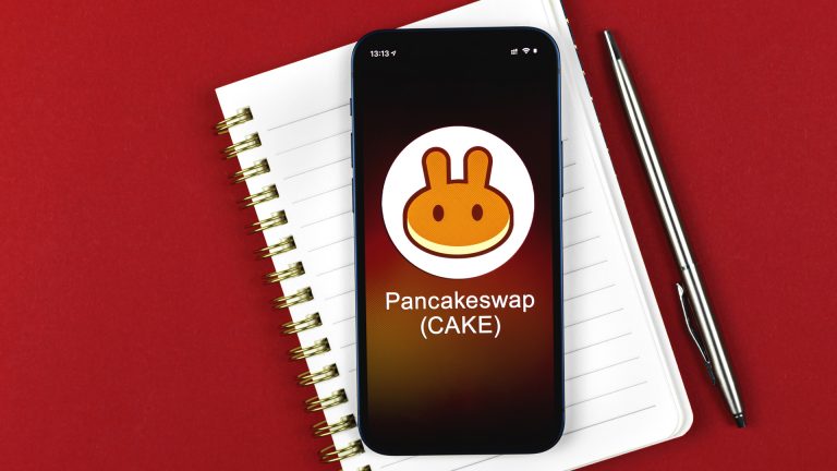 Lista em caderno e aplicativo com imagem da PancakeSwap CAKE deslistar