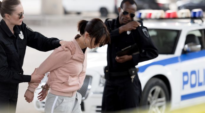 Mulher sendo presa por policiais