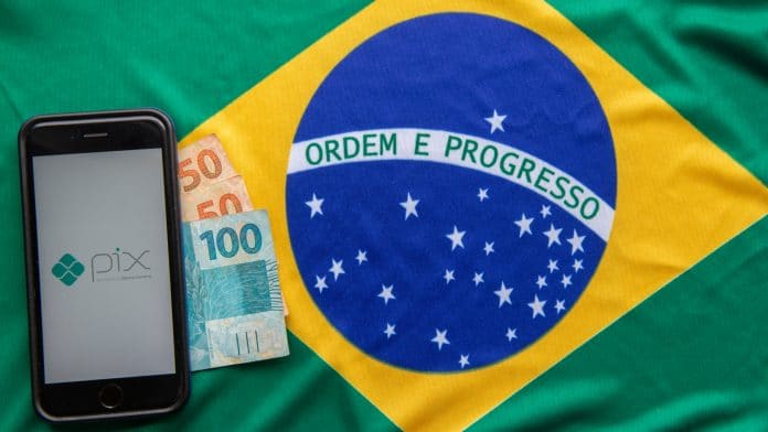 Aplicativo do PIX, notas de Real brasileiro e bandeira do Brasil
