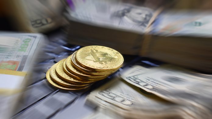 Bitcoin em meio a notas de dólar