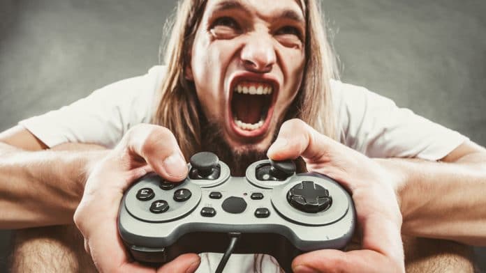 Gamer com controle na mão nervoso e frustrado jogo problema defeito golpe