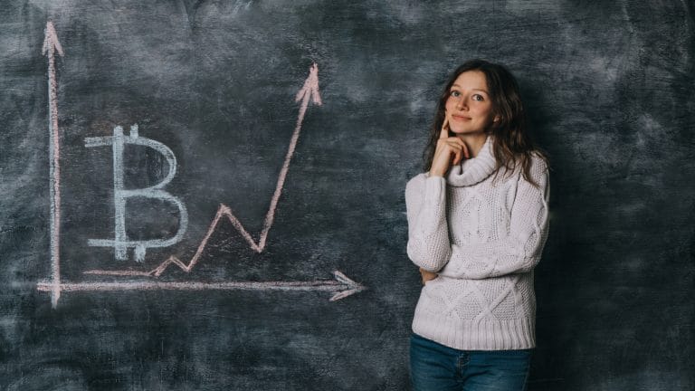 Garota assistindo o gráfico do bitcoin desenhado na lousa com giz