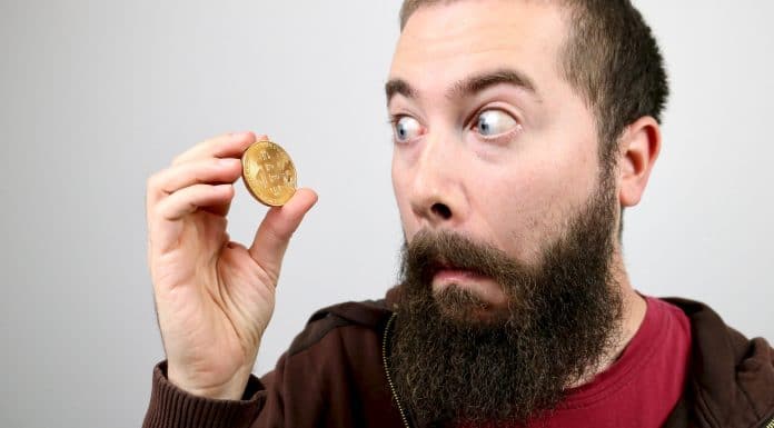 Homem jovem com barba olhando para o Bitcoin