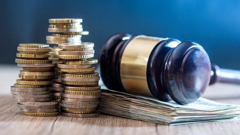 Martelo da Justiça com notas e moedas de dinheiro próximas