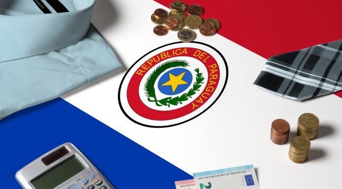 Moedas e objetos financeiros na superfície da bandeira do Paraguai, crime do colarinho branco