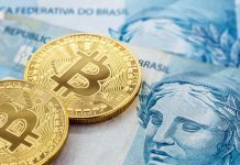 Notas de R$ 100 do Real brasileiro e moedas de Bitcoin