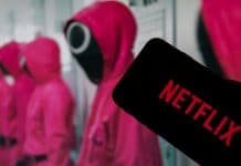 O logotipo da Netflix na tela de um smartphone na frente de uma televisão com a série Squid Game