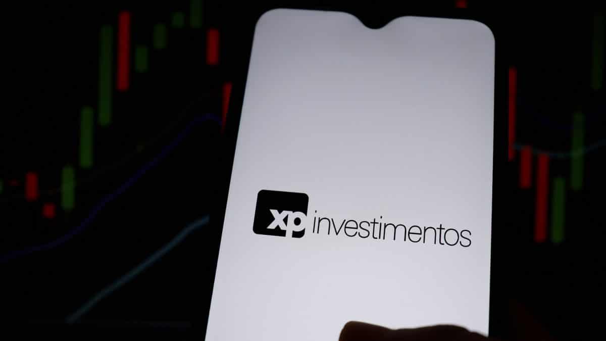 XP Investimentos e gráficos ao fundo