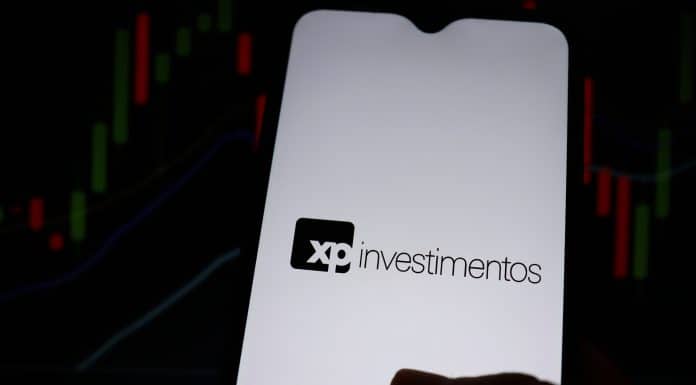 XP Investimentos e gráficos ao fundo