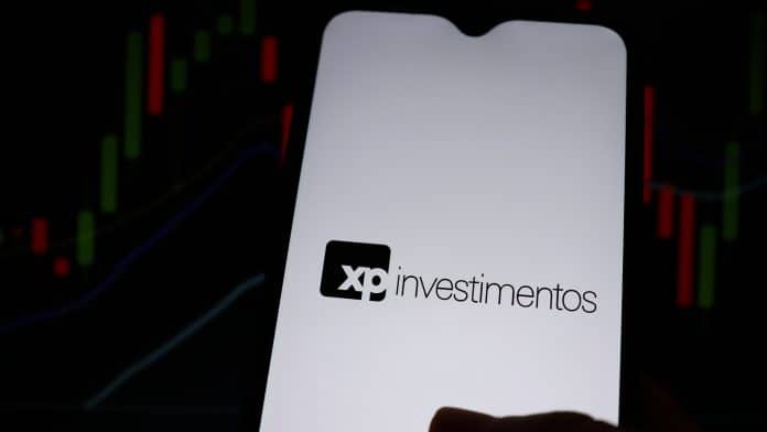 XP Investimentos e gráficos ao fundo