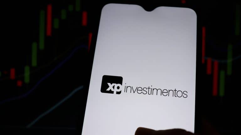 XP Investimentos e gráficos ao fundo
