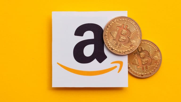 Logo da Amazon e criptomoeda física de Bitcoin
