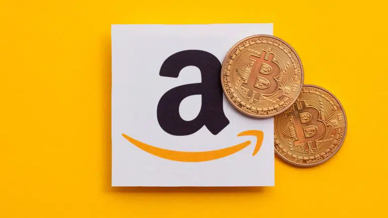 Logo da Amazon e criptomoeda física de Bitcoin