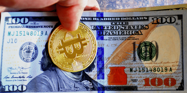 Nota de dólar e moeda de Bitcoin (BTC)