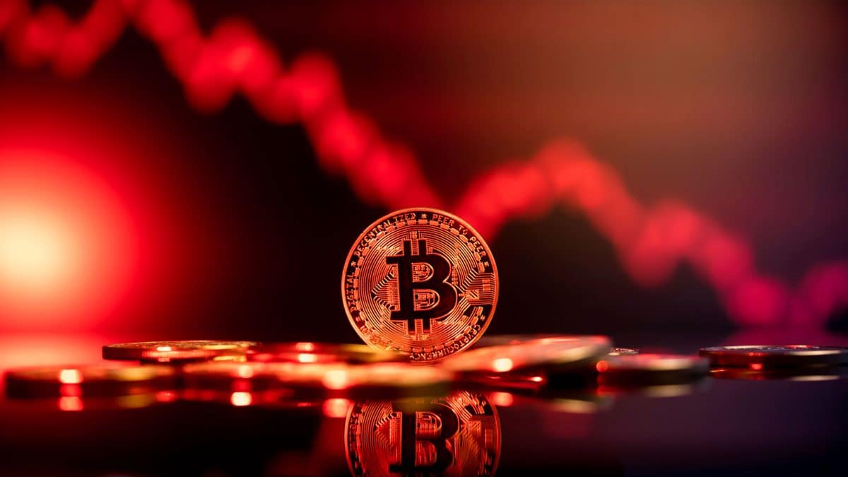 Moeda de Bitcoin com gráfico caindo