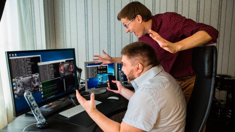 Mineradores felizes em frente ao computador.