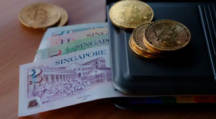 Notas de dólar de Singapura e criptomoeda Bitcoin