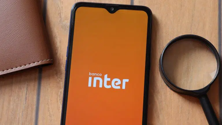 Aplicativo Banco Inter na tela do smartphone, lupa e carteira