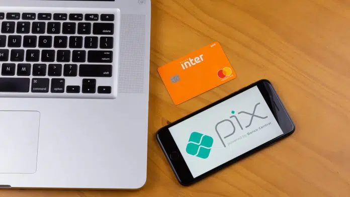 Cartão do Banco Inter próximo de aplicativo com símbolo do PIX em celular