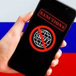 Celular com bandeira do SWIFT em sanção com bandeira da Rússia ao fundo