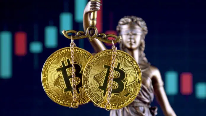Estátua da justiça segurando Bitcoin e criptomoedas