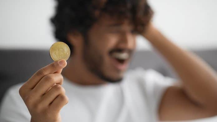 Homem frustrado segurando Bitcoin