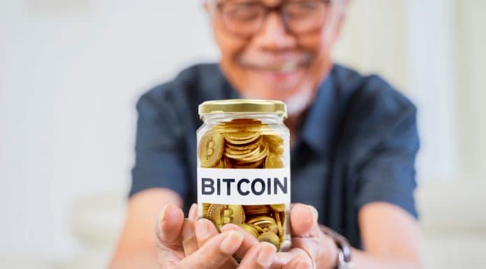 Homem idoso segurando pote com Bitcoin