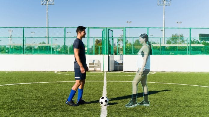 Jovem conectado ao metaverso jogando futebol com uma mulher virtual