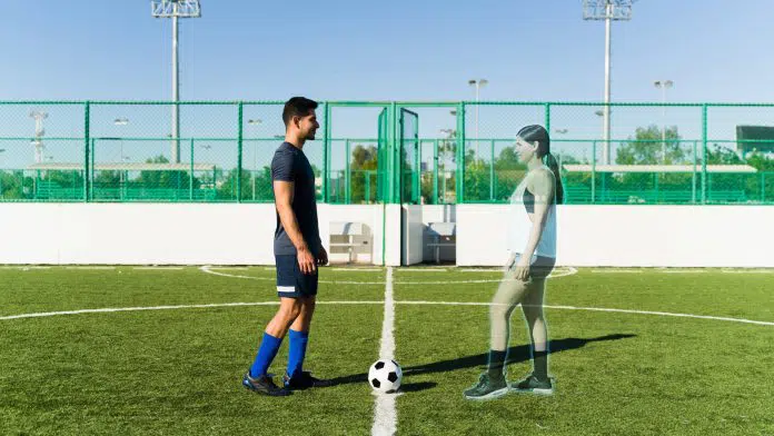 Jovem conectado ao metaverso jogando futebol com uma mulher virtual