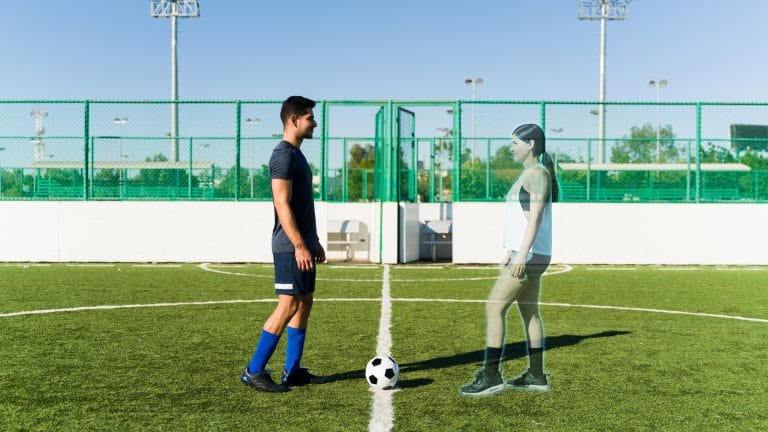 Jovem conectado ao metaverso jogando futebol com uma mulher virtual