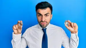 Jovem segurando criptomoedas nervoso