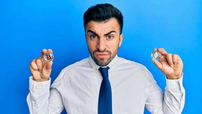 Jovem segurando criptomoedas nervoso