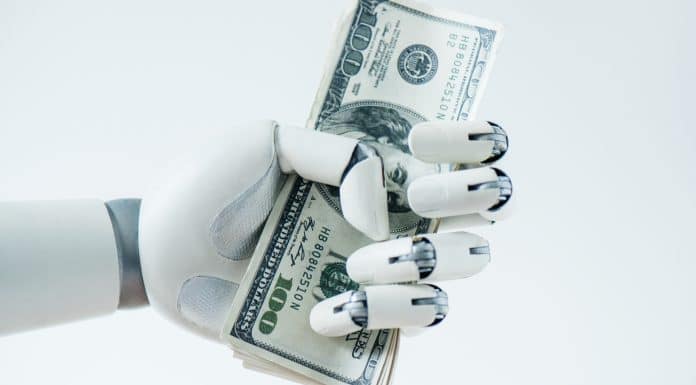 Mão de robô amassando nota de dinheiro