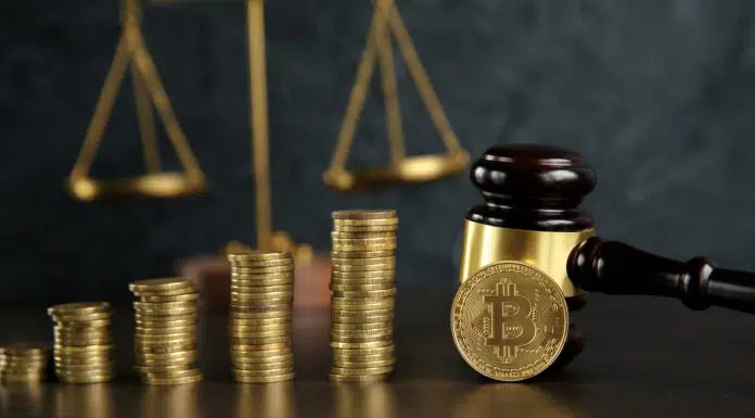 Martelo e balança da justiça próximo de pilhas de Bitcoins
