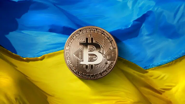 Moeda Bitcoin em frente a bandeira da Ucrânia