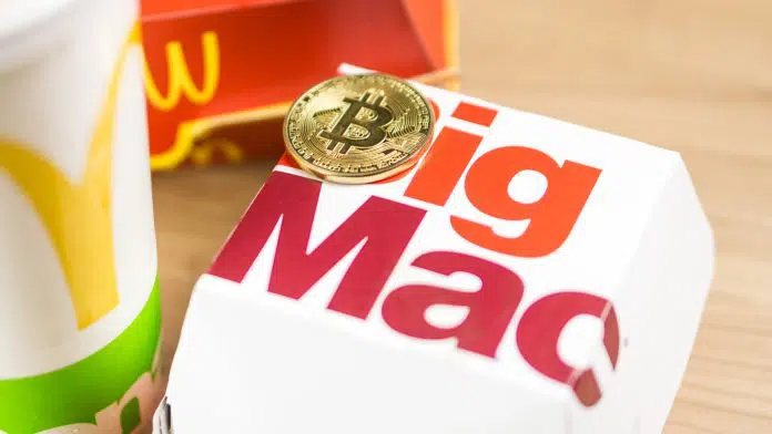 Moeda de Bitcoin substituindo o B de Big Mac, lanche popular do McDonalds