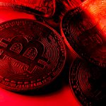 Moedas torcidas com símbolo de bitcoin na luz vermelha