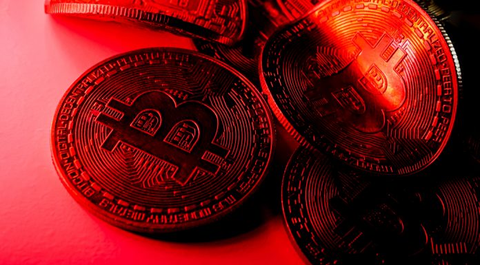 Moedas torcidas com símbolo de bitcoin na luz vermelha