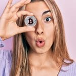 Mulher segurando bitcoin com medo