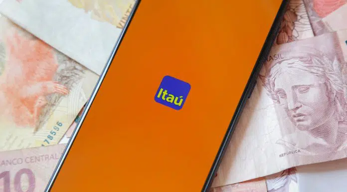 Tela do aplicativo do banco Itaú com notas de Real ao fundo