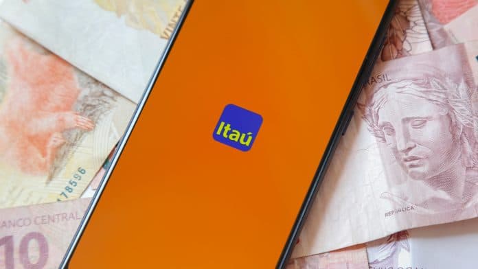 Tela do aplicativo do banco Itaú com notas de Real ao fundo