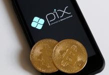 Tela do celular com logotipo PIX e criptomoedas Bitcoin