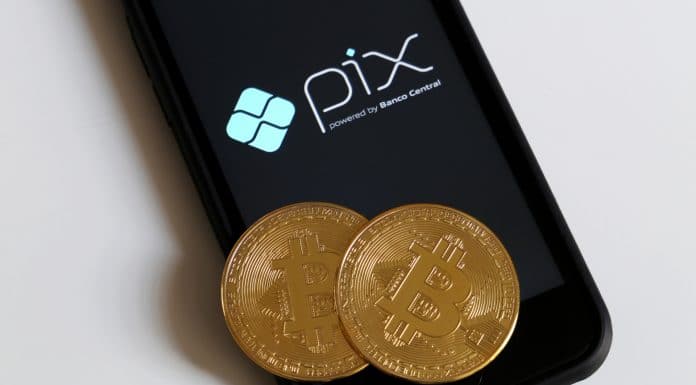 Tela do celular com logotipo PIX e criptomoedas Bitcoin